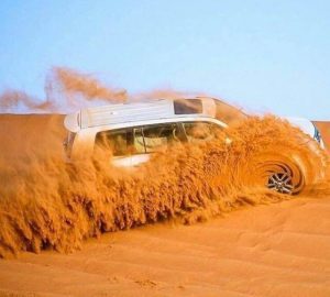 Luxury SUV driving through Dubai desert dunes on thrilling safari adventure